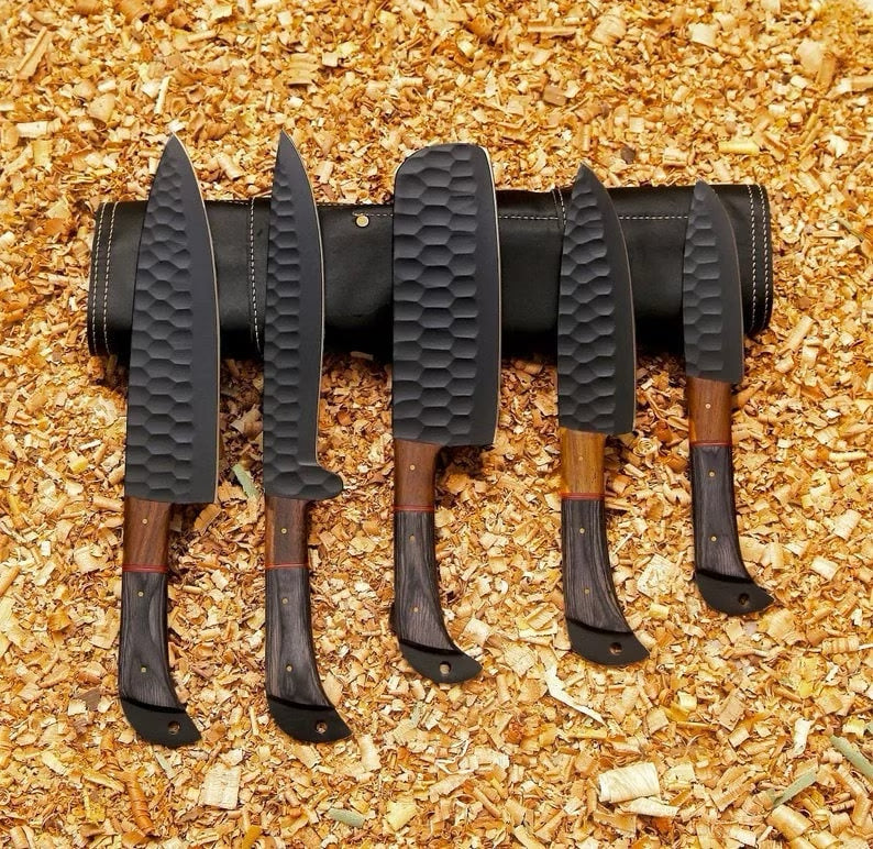 Handmade kitchen knife set by Knives Gear Garage with stainless steel blades and wooden handles, displayed on a wooden countertop.