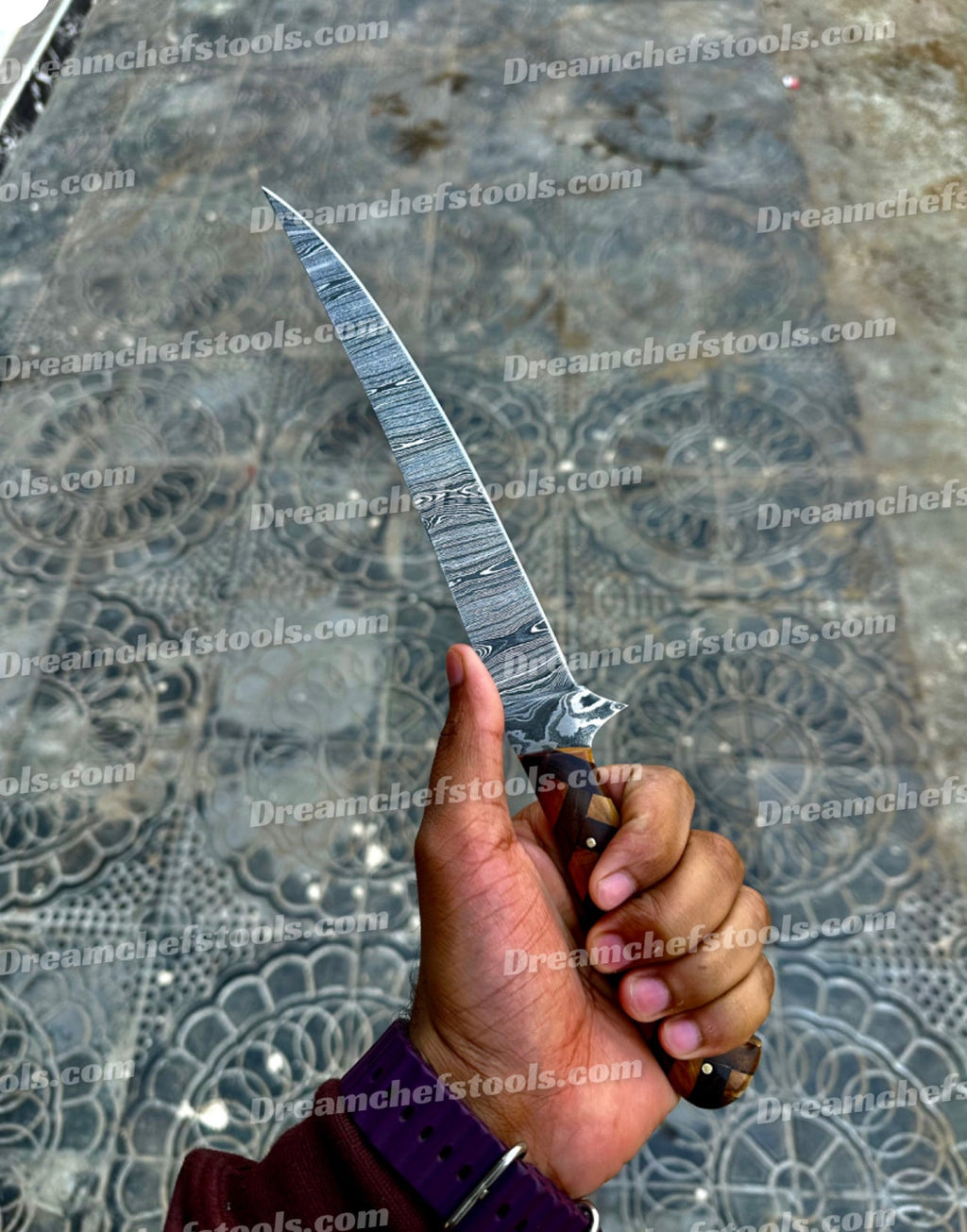Close-up of a Damascus steel fillet knife with a detailed custom rosewood and olive wood handle, 13-inch overall length.