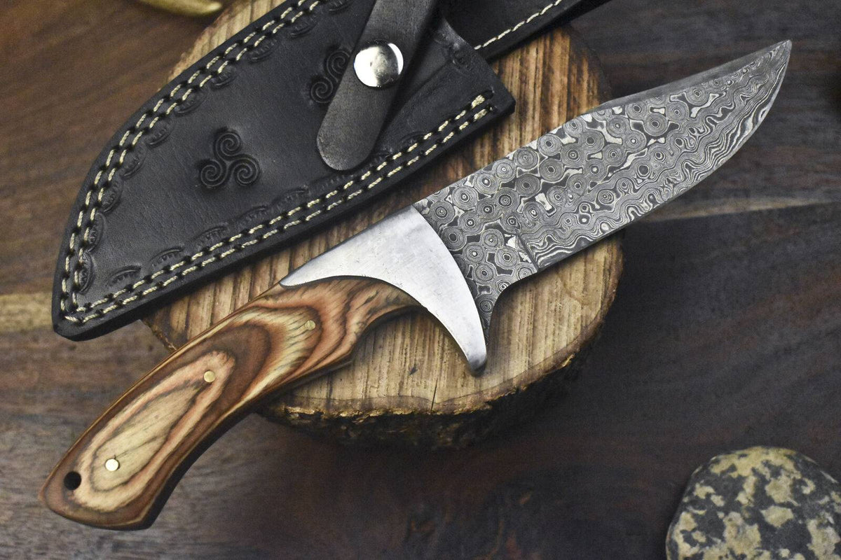 Close-up of Knives Gear Garage custom handmade J2 steel hunting knife with pakkawood handle, steel bolster, and leather sheath.