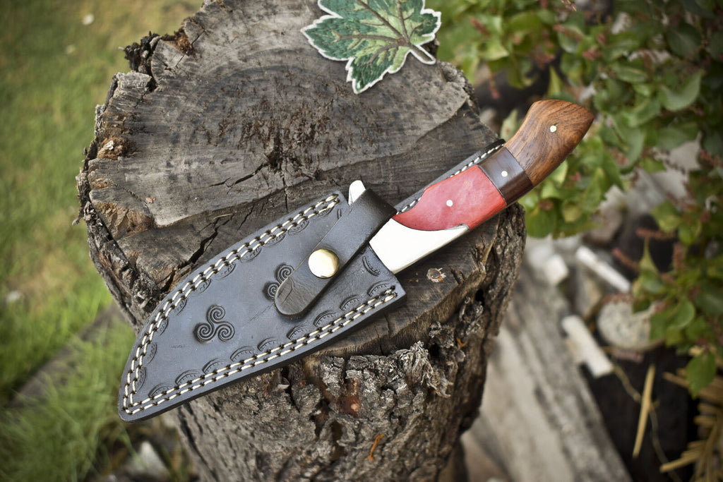 Custom handmade Damascus steel hunting knife with pakkawood and rosewood handle, steel bolster, and leather sheath.