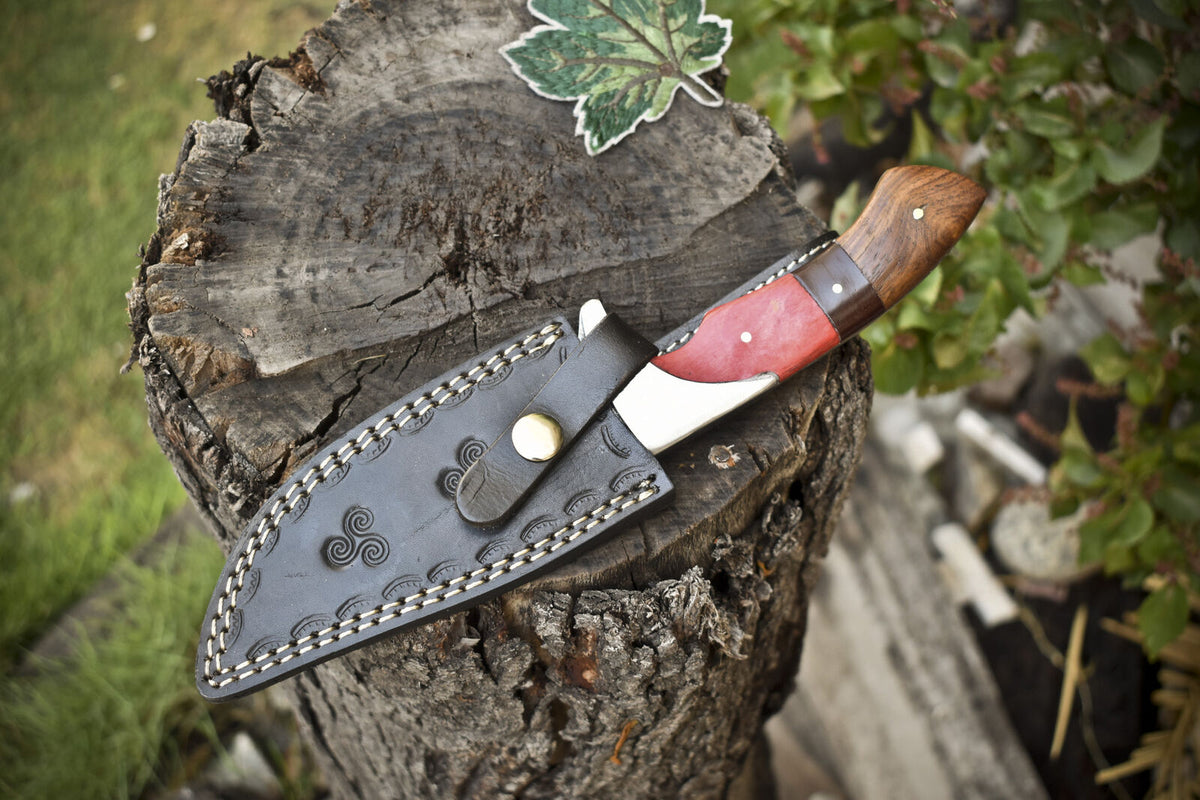 Custom handmade Damascus steel hunting knife with pakkawood and rosewood handle, steel bolster, and leather sheath.