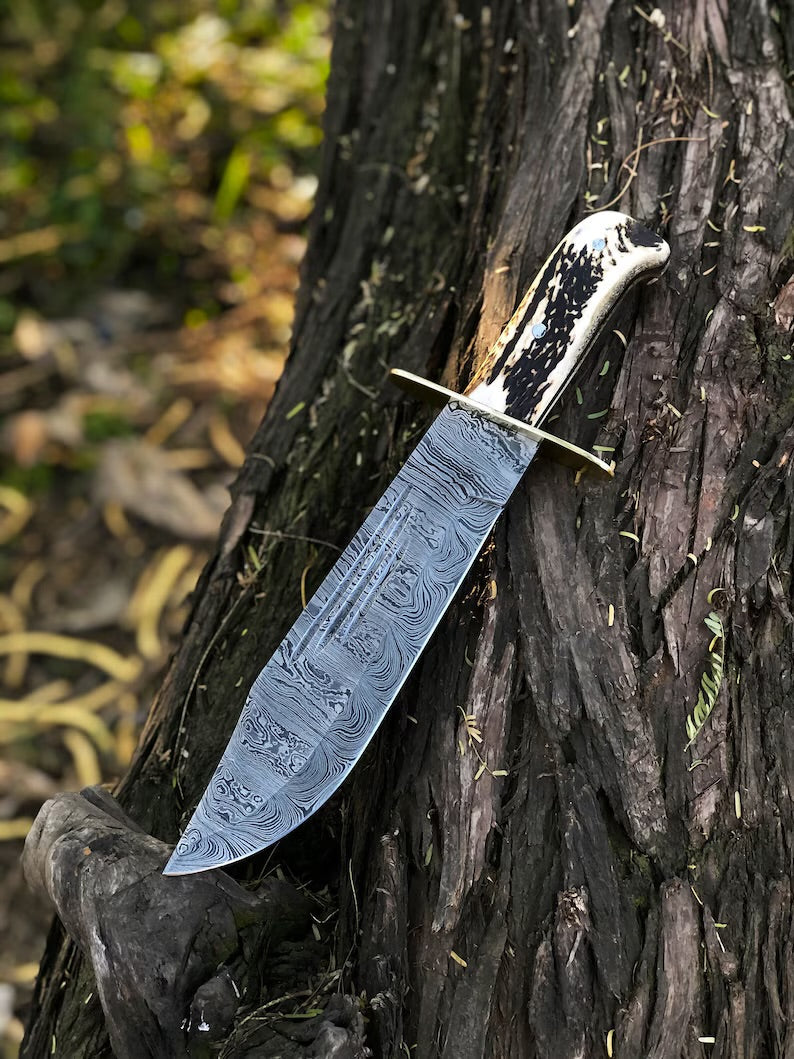 Custom handmade 15-inch Damascus steel Bowie knife with stag handle, brass guard, and leather sheath by Knives Gear Garage.