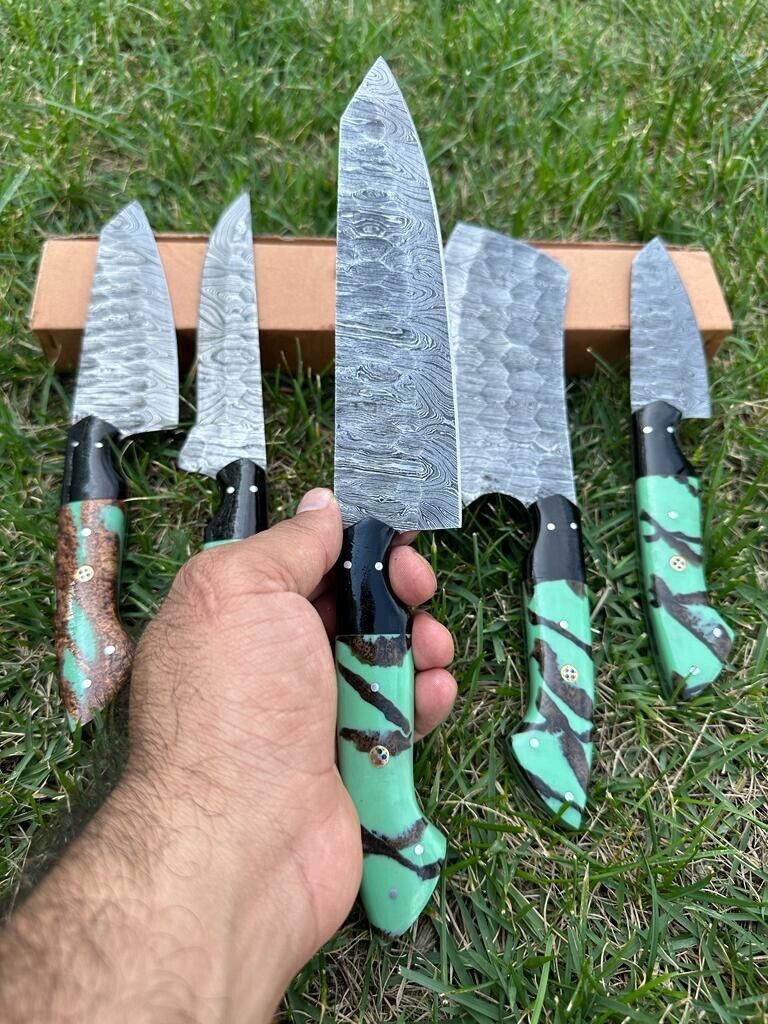 Custom handmade Damascus steel kitchen knife set by Knives Gear Garage with 9 to 13-inch blades, resin and wood handles, in leather roll kit.