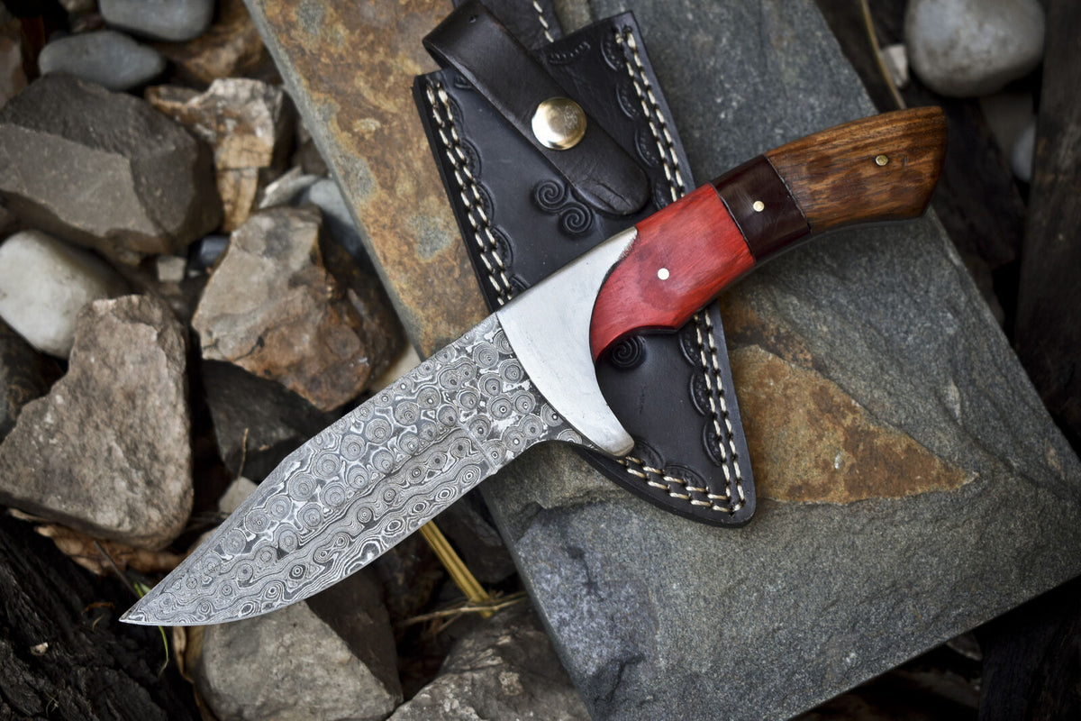 Custom handmade Damascus steel hunting knife with pakkawood and rosewood handle, steel bolster, and leather sheath.