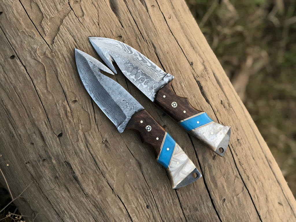 Custom handmade Damascus steel Guthook hunting knife with leather sheath by Knives Gear Garage, featuring a detailed Damascus blade and wooden handle.