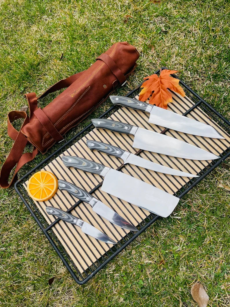 Custom handmade J2 Steel kitchen knife set by Knives Gear Garage with G10 handles, steel bolsters, and leather roll kit.