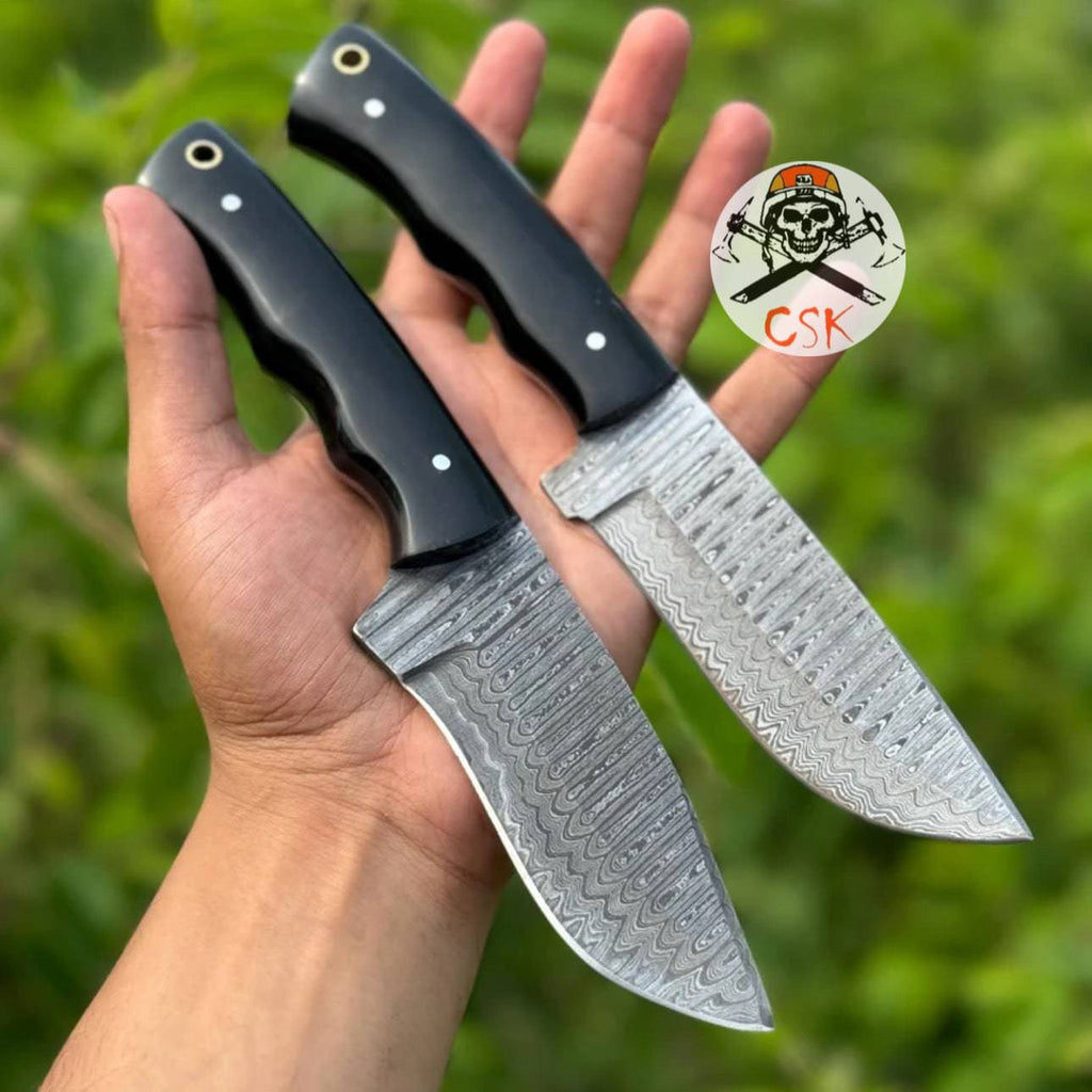 Pair of premium hand-forged Damascus steel hunting knives with ergonomic black handles by cskforged, featuring high-performance blades.