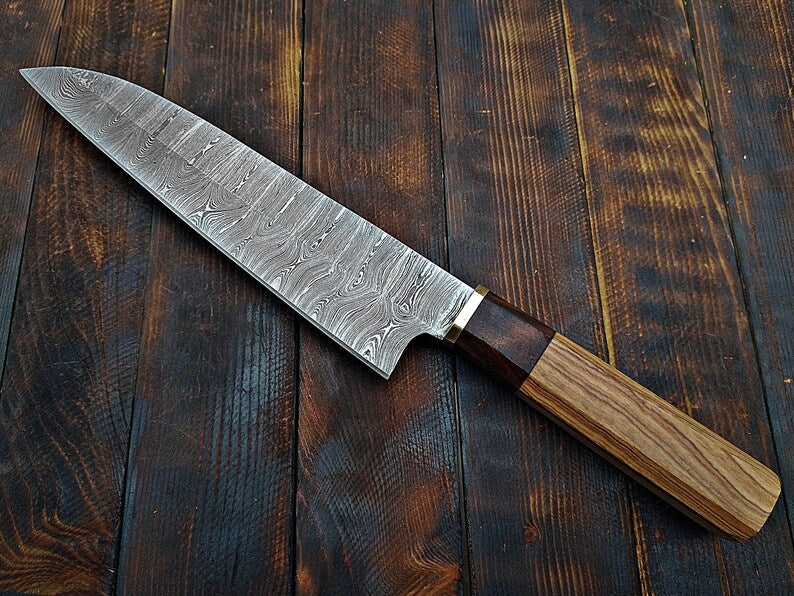 Handmade Damascus chef knife with a wooden handle and intricate blade pattern from Knives Gear Garage.