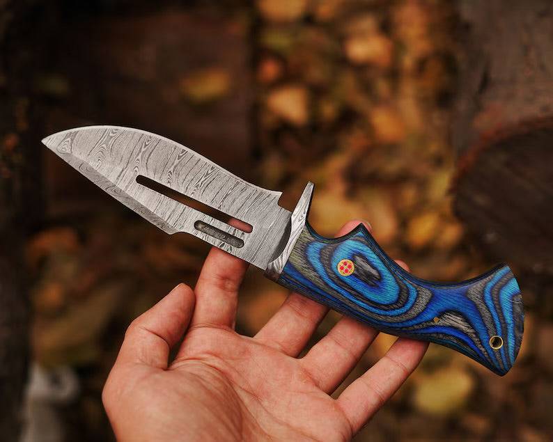 Damascus steel hunting knife by cskforged with a textured handle and sharp blade, ideal for outdoor hunting and survival tasks.