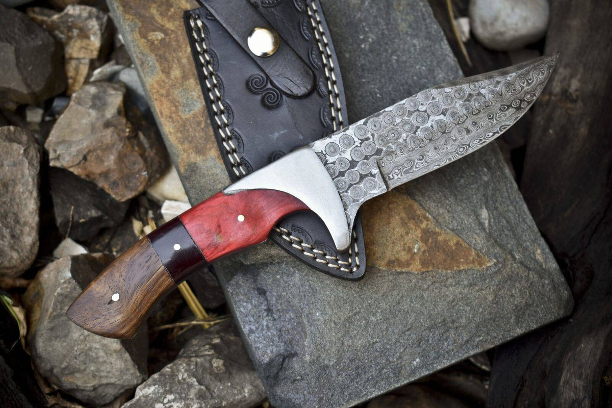 Handmade Damascus steel hunting knife with pakkawood and rosewood handle, steel bolster, and leather sheath.
