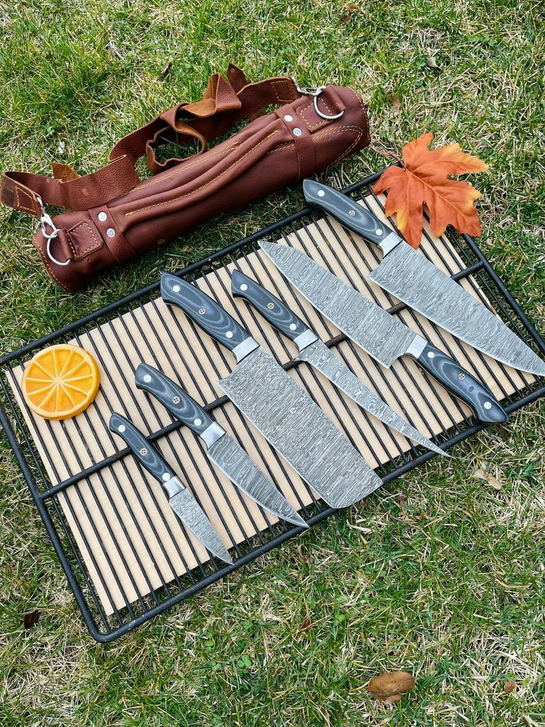 Luxury custom handmade Damascus steel kitchen knife set with G10 handles and steel bolsters in a leather roll kit