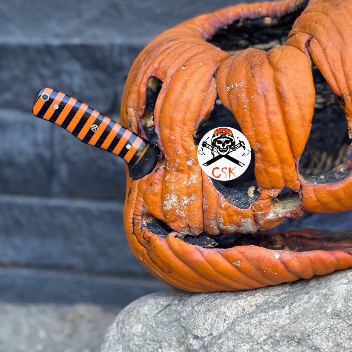 Black-and-orange striped hunting knife by cskforged, featuring a custom Halloween-themed design and a sharp, durable blade.