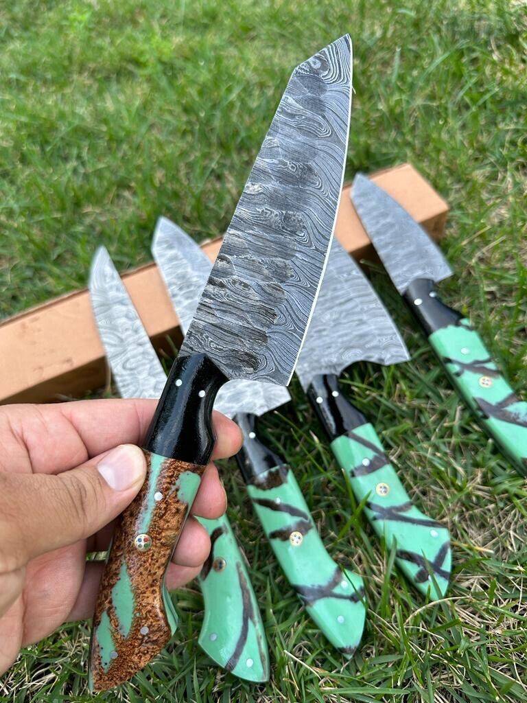 Custom handmade Damascus steel kitchen knife set from Knives Gear Garage displayed on a wooden cutting board showing unique patterns and sharp blades.