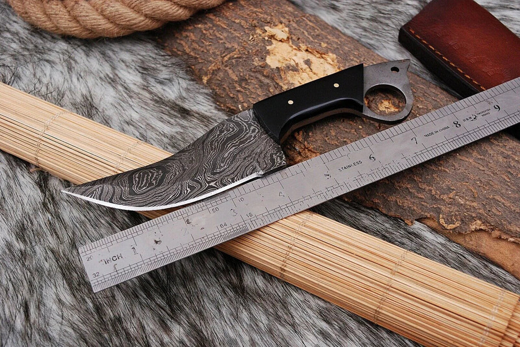 Custom handmade Damascus steel hunting knife with buffalo horn handle, featuring intricate blade patterns and durable craftsmanship.
