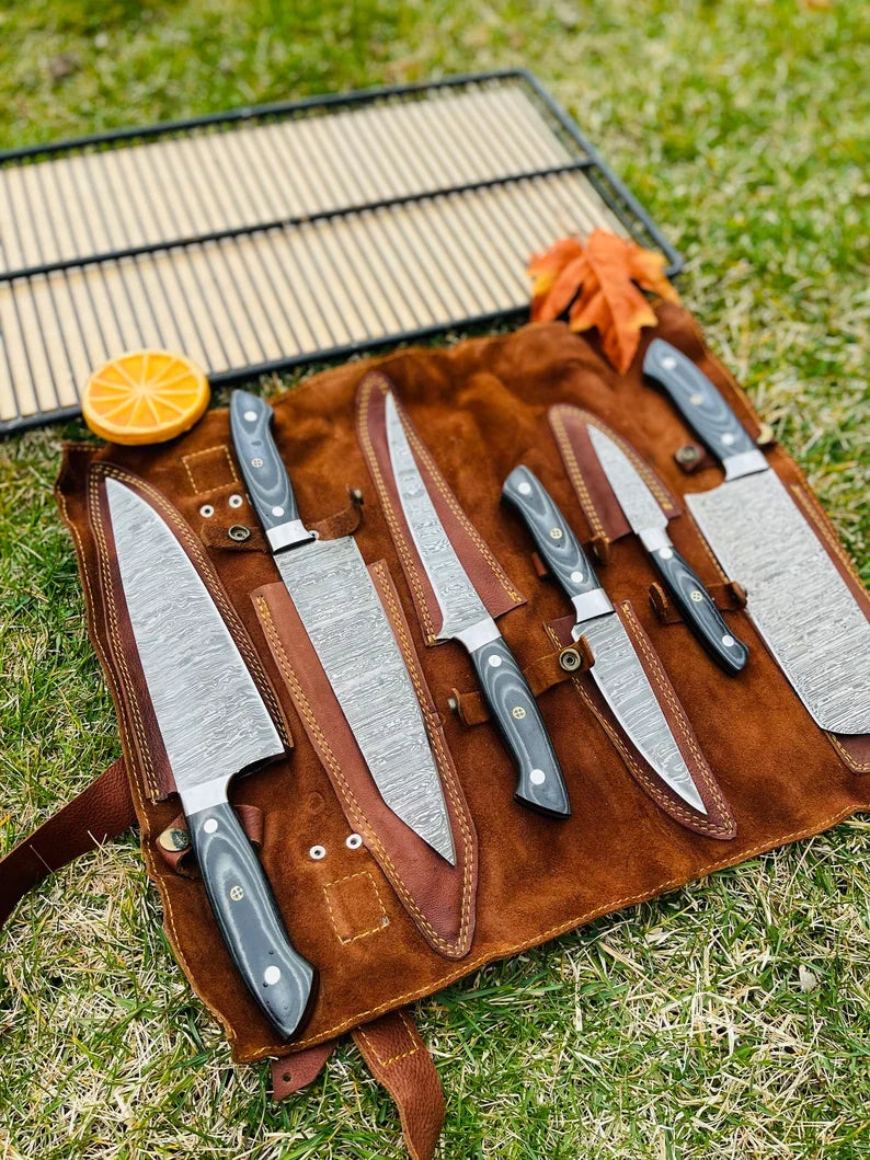 Luxury handmade Damascus steel kitchen knife set by Knives Gear Garage with G10 handles and steel bolsters in leather roll kit.
