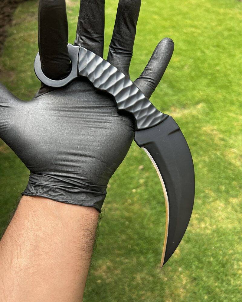 Black powder-coated Karambit knife by Knives Gear Garage, featuring a curved blade and ergonomic handle for EDC use.