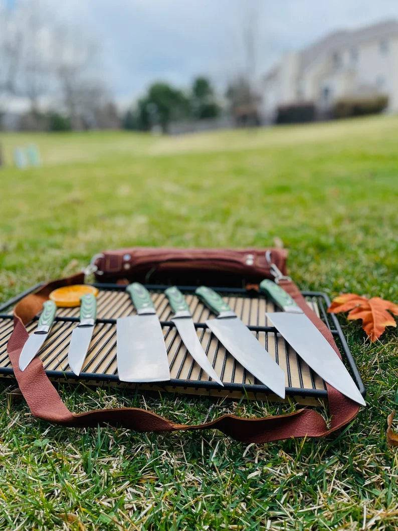 Custom Handmade J2 Steel kitchen knife set with G10 handles, steel bolsters, and leather roll storage by Knives Gear Garage.