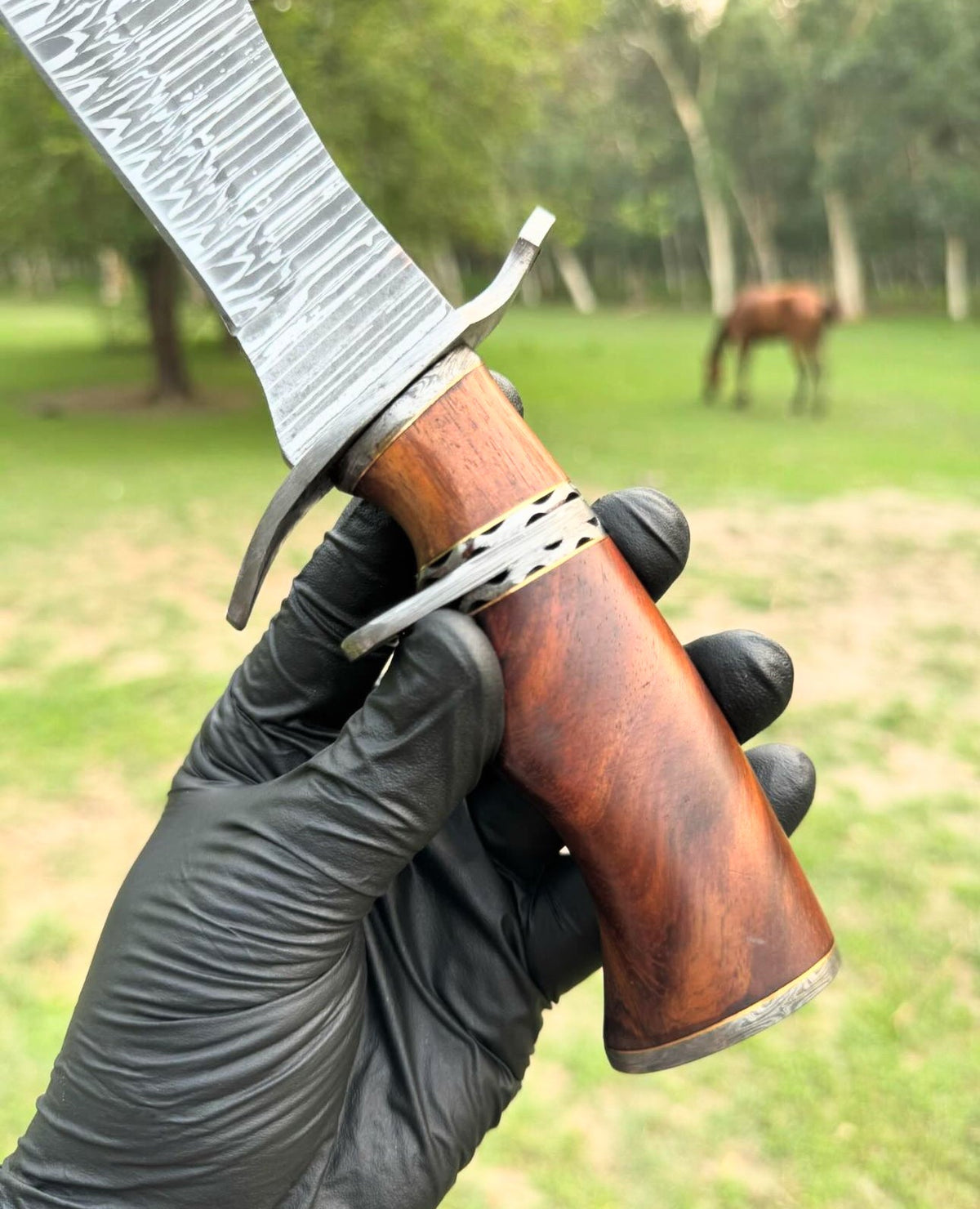 Custom handmade Damascus steel hunting Bowie knife with wooden handle, detailed blade design, crafted by Knives Gear Garage.