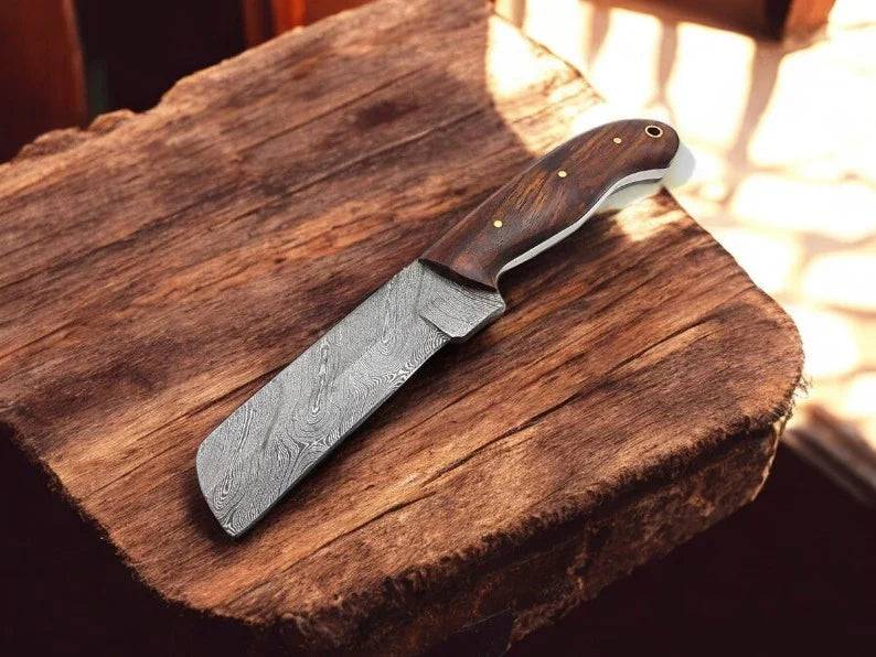 Custom handmade bull cutter knife by cskforged with leather sheath, featuring a polished blade and rustic leather handle.