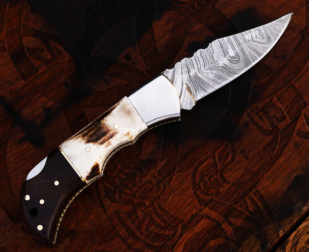Damascus steel pocket knife with stag and rose wood handle, handmade folding knife by CSKForged, detailed blade and handle craftsmanship.