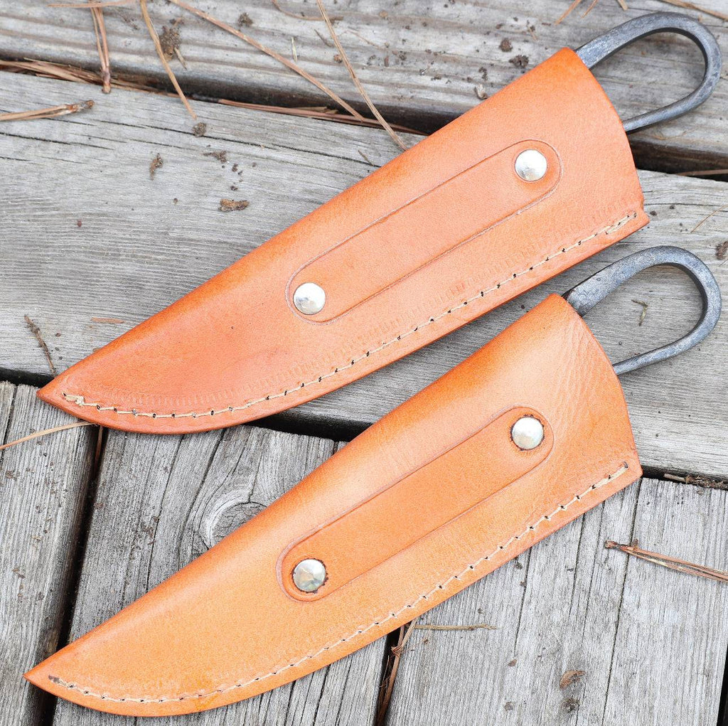 Pair of cskforged medieval-inspired hunting knives with hand-forged iron blades and genuine leather sheaths for authentic feasting or hunting.