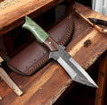 Full view of cskforged camel bone handle Damascus steel hunting knife with a sharp blade and intricate forging details.