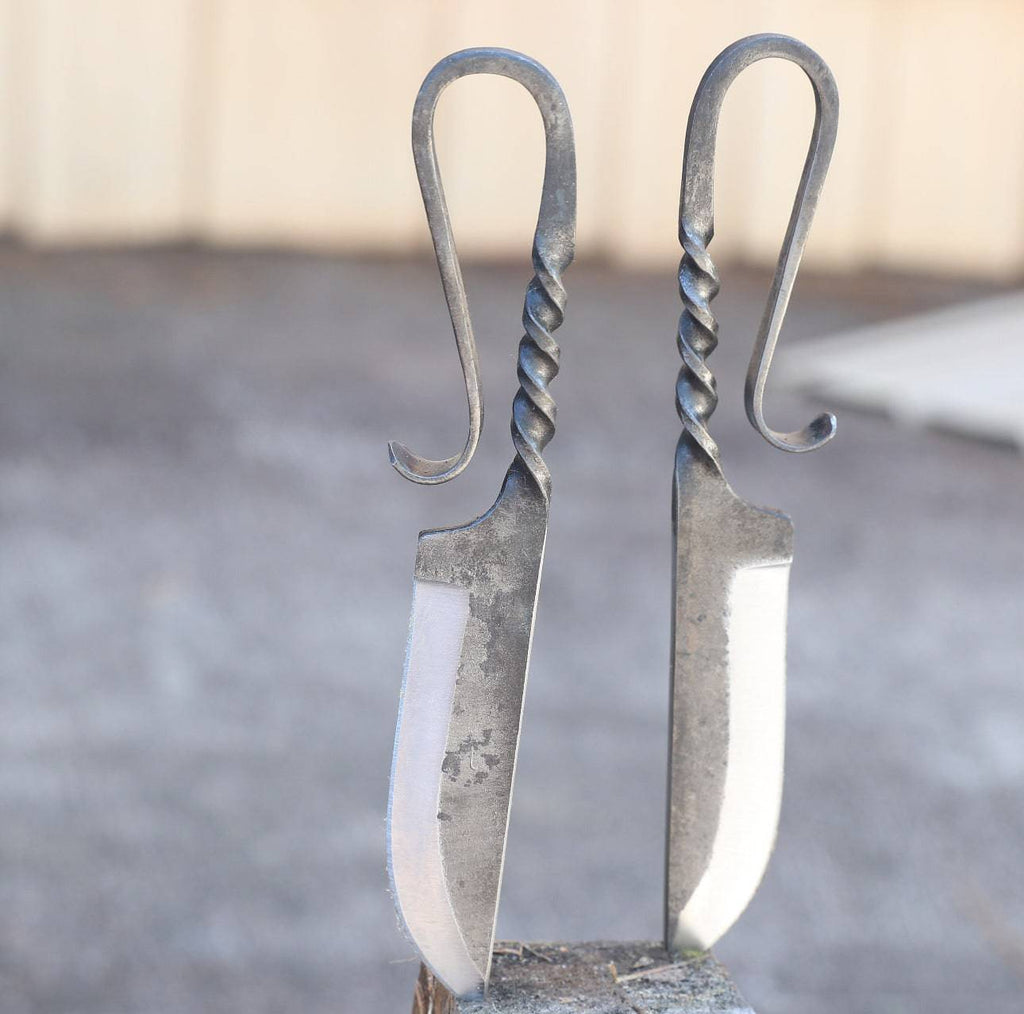 Two medieval-inspired forged iron hunting knives by cskforged with leather sheaths, designed for authentic feasting and outdoor use.