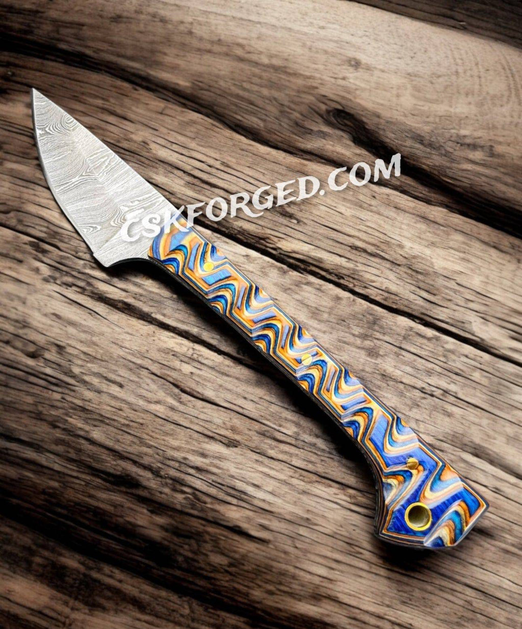 Close-up of the Prideful Fang Caping Damascus 6.6-inch EDC survival knife by cskforged, showing its detailed Damascus blade and handle.