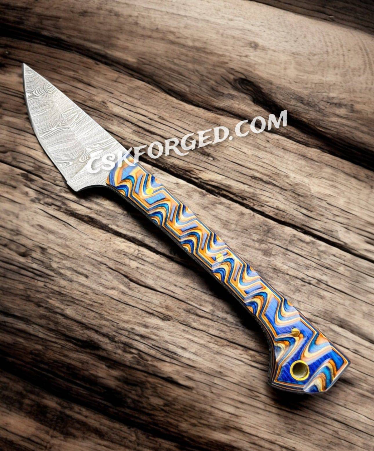 Close-up of the Prideful Fang Caping Damascus 6.6-inch EDC survival knife by cskforged, showing its detailed Damascus blade and handle.