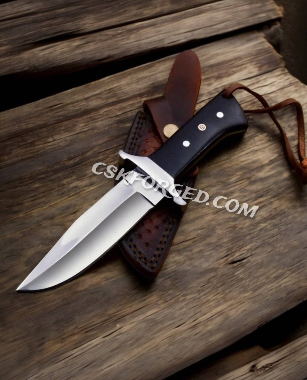 CSKforged Loveless Style D2 Steel hunting knife with black Micarta handle and leather sheath, full view of the outdoor-ready knife.