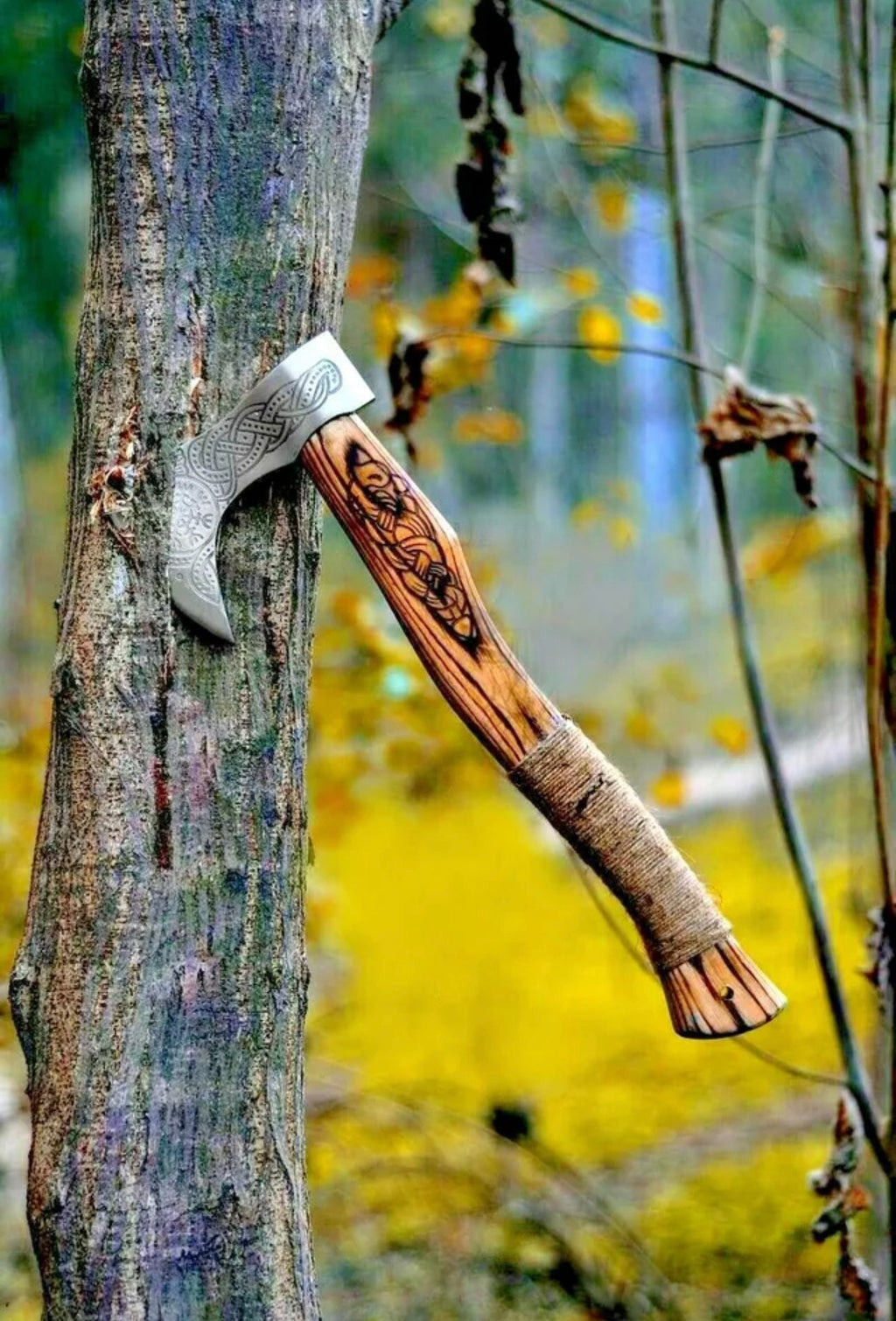 Custom Viking axe by Knives Gear Garage with wooden handle and metal blade, displayed on a plain background.