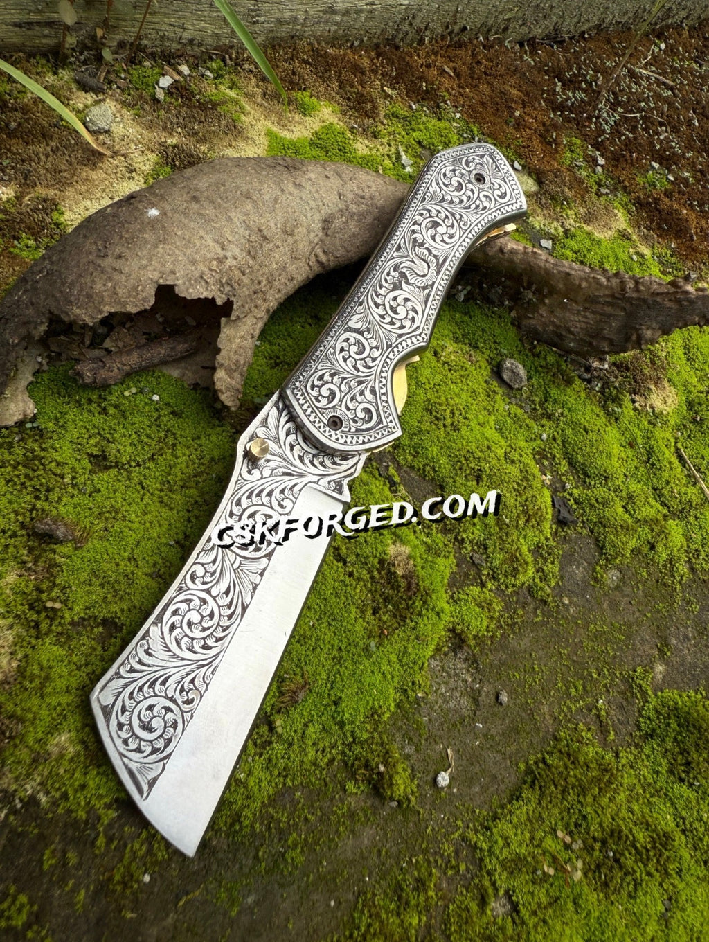 Hand-engraved scrollwork pocket knife by cskforged with detailed metalwork and a classic folding blade.