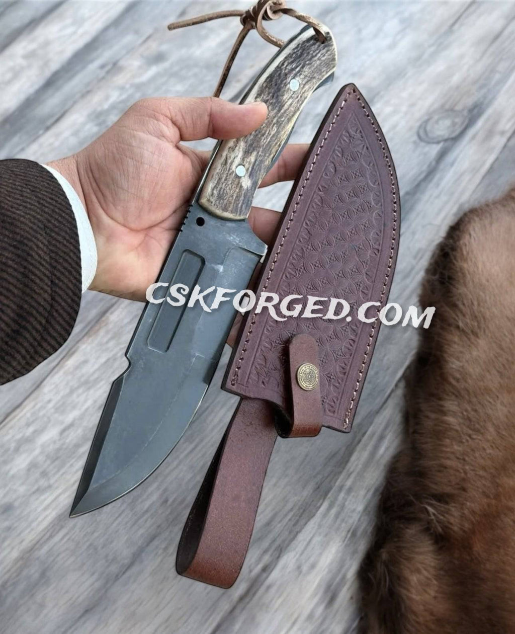 D2 steel hunting and survival knife with antler handle, featuring a full tang blade and textured grip for outdoor use.