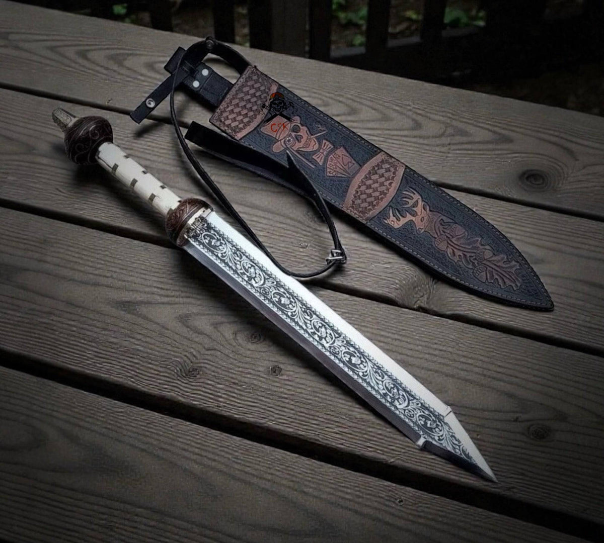 Roman ornate gladiator knight sword by cskforged with engraved blade, bone handle, and skull deer leather sheath.