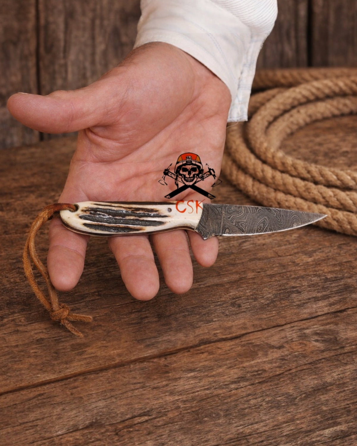 Old Buckaroo 3.5-inch Damascus cowboy knife by cskforged with a pancake leather sheath, featuring a traditional Western knife design.