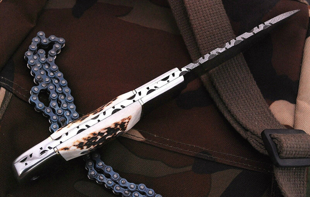 Handmade Damascus steel hunting knife handle with stag horn, showcasing intricate craftsmanship and natural wood grain details.