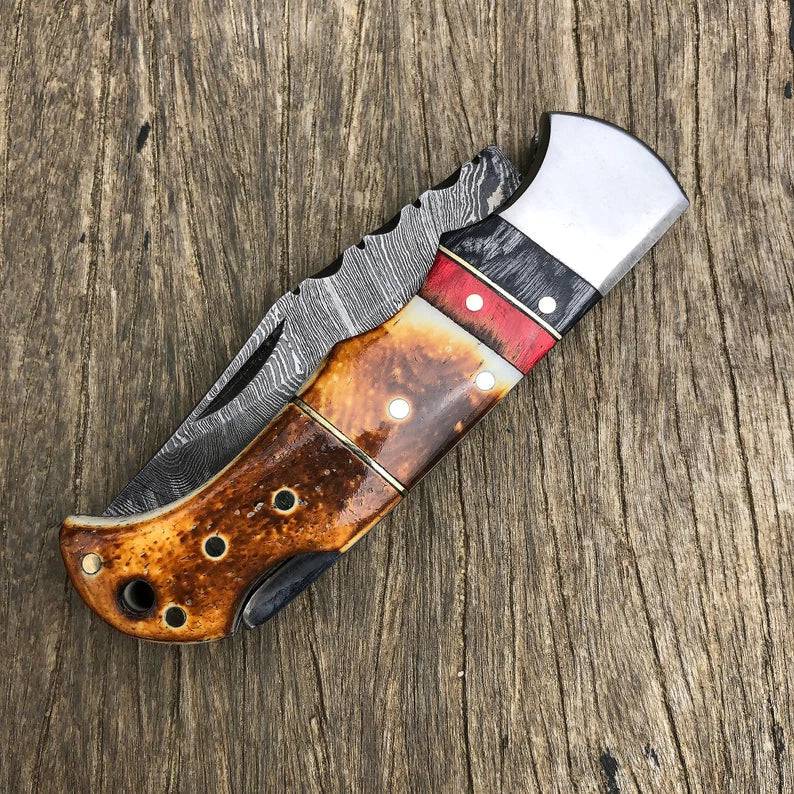 Damascus folding pocket knife by cskforged with handmade burnt camel bone handle, showcasing intricate Damascus steel pattern.