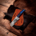 Damascus Bull Cutter Knife by cskforged with handcrafted wood handle and leather belt sheath, ideal EDC tool.