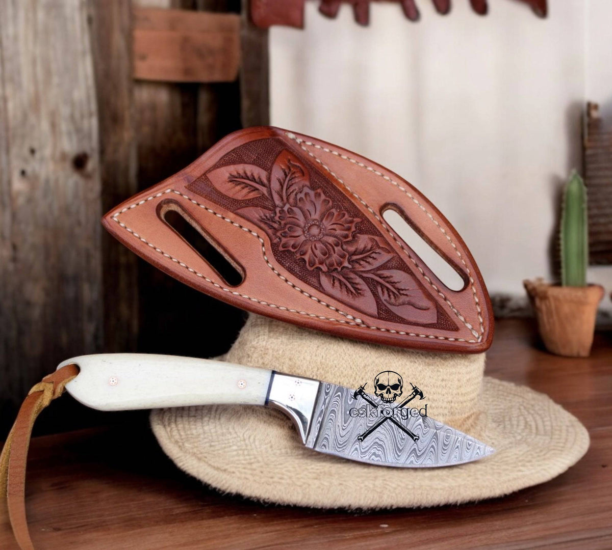 Frontier Ranger Old West EDC knife by cskforged, featuring a leather handle and stainless steel blade, displayed on a wooden surface.