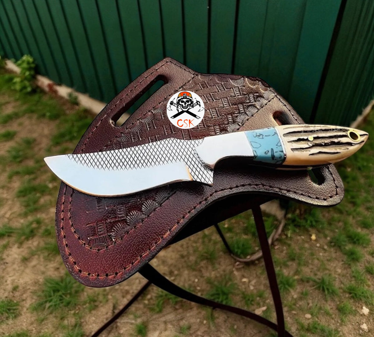 Cross draw hunting sheath knife with rasp steel blade and antler handle, crafted by cskforged in a detailed outdoor setting.
