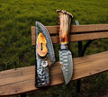 Handmade hunting knife with antler handle and steel blade by cskforged, displayed on a wooden surface.