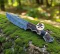 CSKforged Feather Damascus Evoke hook knife with antler handle, a hunting knife featuring a Damascus steel blade and ergonomic handle.