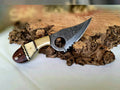 Damascus steel EDC skinning knife with bone-rose wood handle, brass bolster, and serrated edge by cskforged.