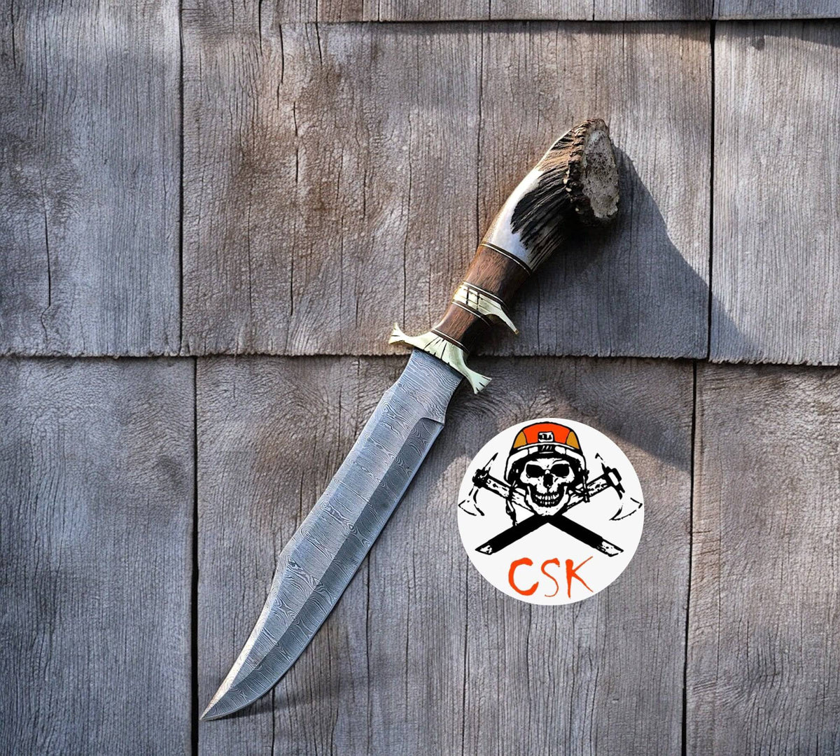 Cskforged 15-inch Damascus steel camping knife with rosewood handle, stag accents, brass guard, and leather sheath.