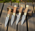 Handmade chef steak knives with Damascus blades in a leather roll kit, crafted by cskforged for precise cutting and elegant presentation.