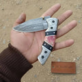 Handmade Damascus folding knife with engraved bolster, black resin and colored bone handle, JW SteelCrafts custom EDC pocket knife.