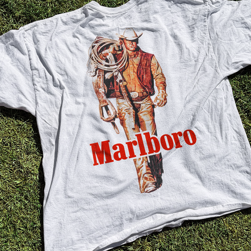 White vintage-style T-shirt featuring the "Cattle Rustler" design by Parallel, with a rustic Western graphic on the front.