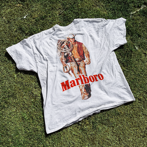 Vintage white "Cattle Rustler" T-shirt by Parallel featuring Western-inspired design on soft cotton fabric.