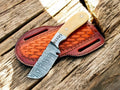 Fixed blade skinning knife with a 3-inch Damascus steel blade and deer bone handle, ideal for hunting and outdoor use.