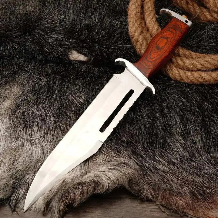 Malika Knives Rambo Bowie Knife with D2 steel blade and wooden handle, shown at an angle highlighting its classic design.